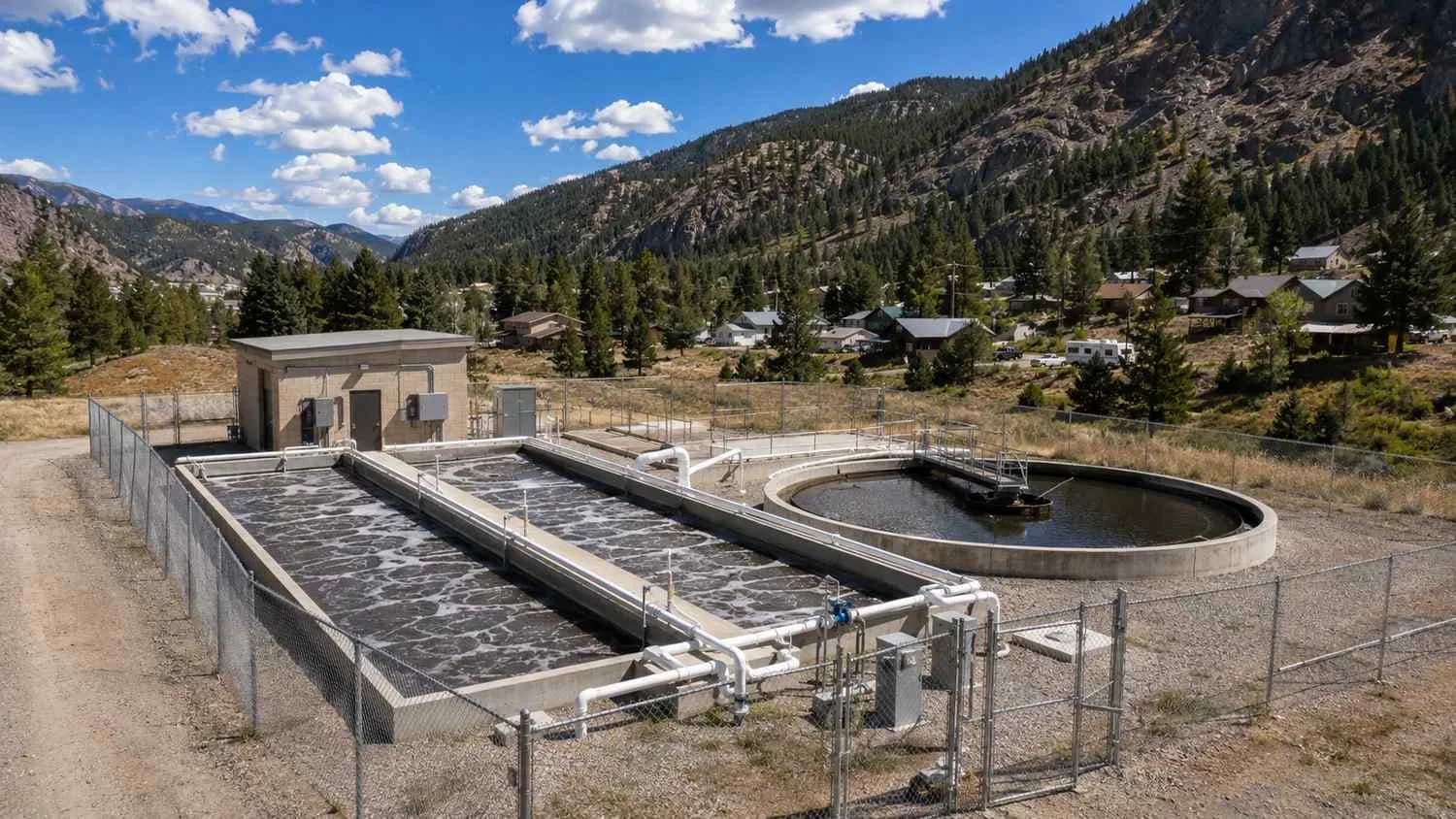 Aerial view of a Colorado rural package wastewater treatment plant with extended aeration tanks and clarifier serving a small mountain community.