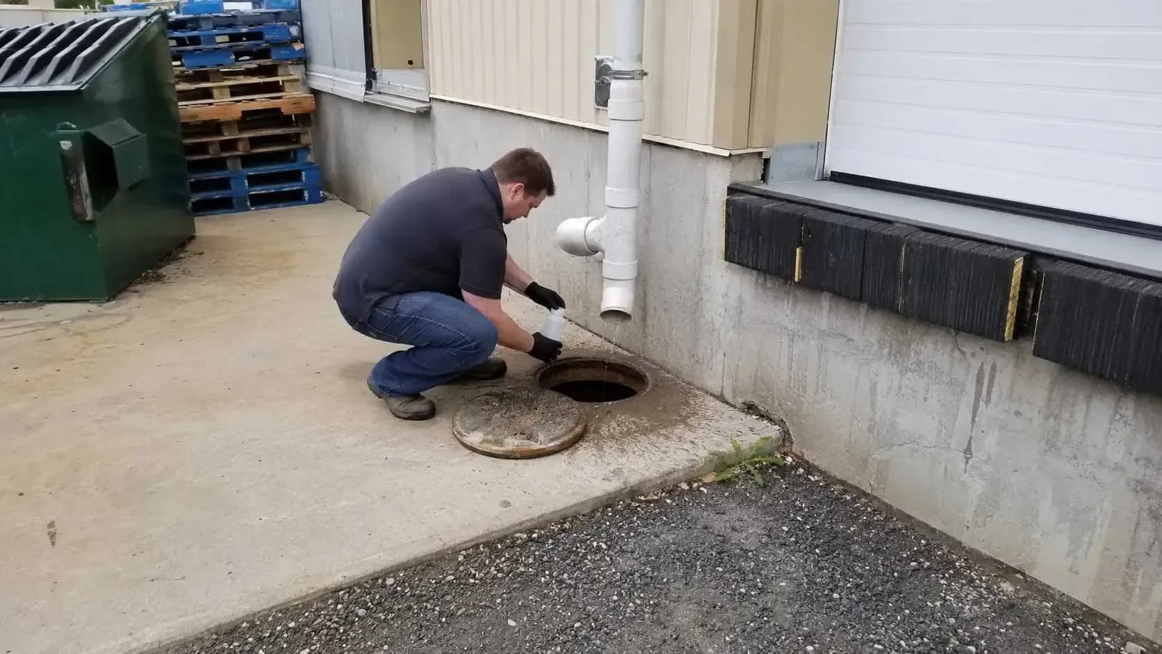 Engineer inspecting a monitoring manhole at an industrial site