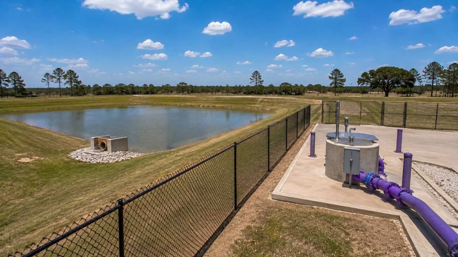 Detention pond and wastewater utility infrastructure on Harris County development site.