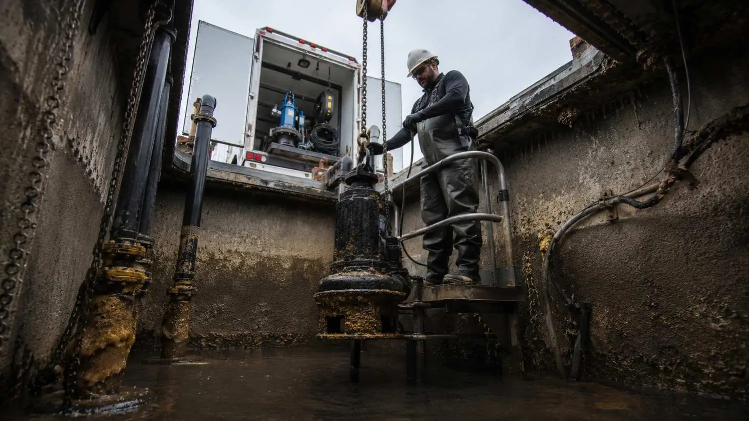 Aging wastewater lift station with worn pump equipment and deteriorating wet well showing conditions that belong in a small community capital improvement plan for scheduled replacement before failure