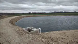 Large earthen wastewater storage reservoir at a Texas reuse facility with treated effluent stored during critical winter months when the irrigation site cannot accept full plant flow under 30 TAC 309.20 requirements