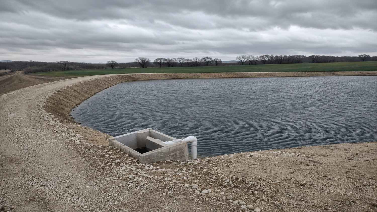 Large earthen wastewater storage reservoir at a Texas reuse facility with treated effluent stored during critical winter months when the irrigation site cannot accept full plant flow under 30 TAC 309.20 requirements