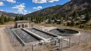 Aerial view of a Colorado rural package wastewater treatment plant with extended aeration tanks and clarifier serving a small mountain community evaluated by Modern Engineering Solutions.