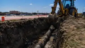 Aging water main excavation in Dallas growth corridor, representing MES utility due diligence services.