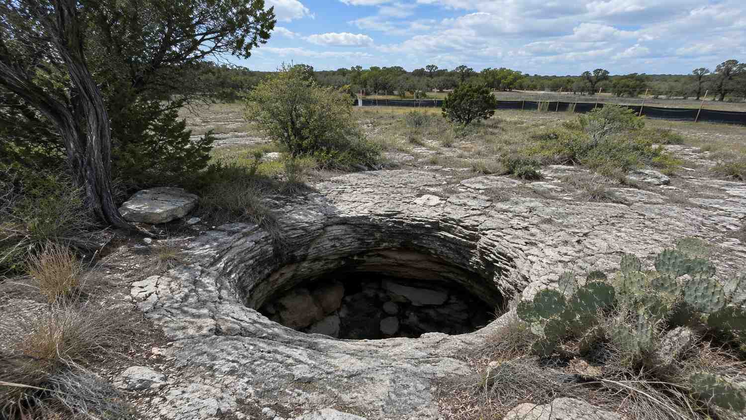 Karst sinkhole feature in Central Texas Hill Country terrain, representing MES sensitive feature setback evaluation.
