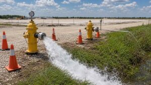 Ground-level shot of a hydrant flow test in progress at a Texas development site with gauges showing static and residual pressure evaluated by Modern Engineering Solutions.