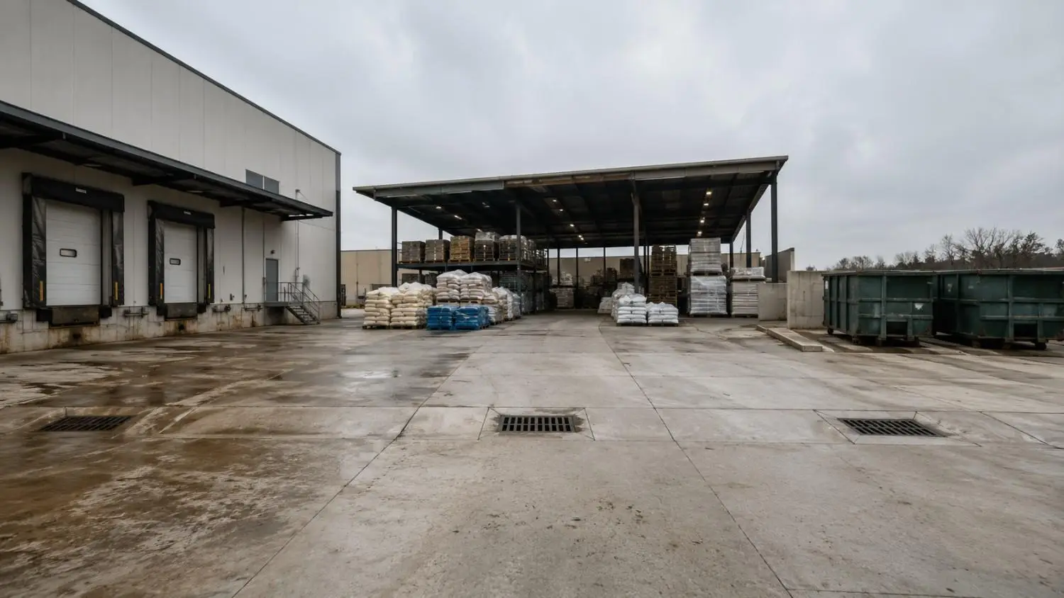 Ground-level shot of a Texas industrial facility outdoor loading dock and material storage area with stormwater drainage channels representing TXR050000 permit trigger zones assessed by Modern Engineering Solutions.