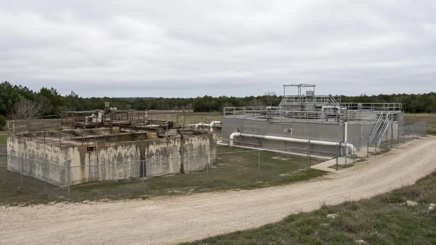 Small Texas municipal wastewater treatment plant showing aging secondary treatment infrastructure beside a newer advanced treatment upgrade addition representing the capital improvement planning driven by TPDES permit renewal and tightened effluent limits that Modern Engineering Solutions supports through engineering and SRF funding applications