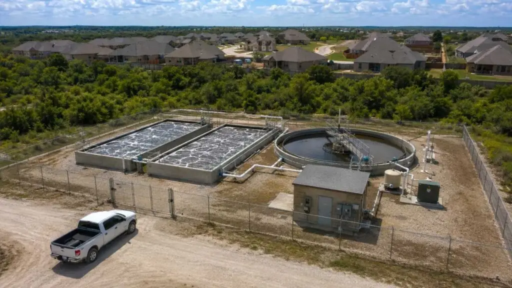 Top-down aerial view of a compact package wastewater treatment plant at a Texas residential development showing extended aeration tanks clarifier and control building sized for the development's design flow representing the correctly engineered facility that Modern Engineering Solutions designs and permits for Texas developers