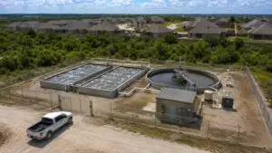 Top-down aerial view of a compact package wastewater treatment plant at a Texas residential development showing extended aeration tanks clarifier and control building sized for the development's design flow representing the correctly engineered facility that Modern Engineering Solutions designs and permits for Texas developers