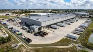 Aerial view of a Texas industrial facility showing outdoor storage yards loading docks and stormwater outfall points evaluated by Modern Engineering Solutions for TXR050000 permit coverage.