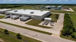 Top-down aerial view of a Texas industrial park showing a food processing facility connected to a municipal sewer collection system with a pretreatment equipment building visible at the facility discharge point representing the industrial user pretreatment requirements for POTW connections